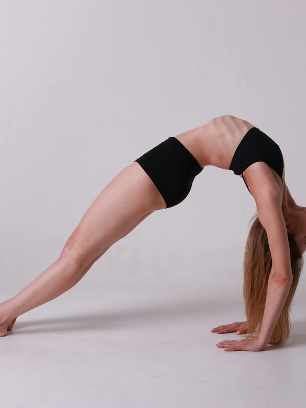 Woman in a calm yoga pose, embodying balance and flexibility.